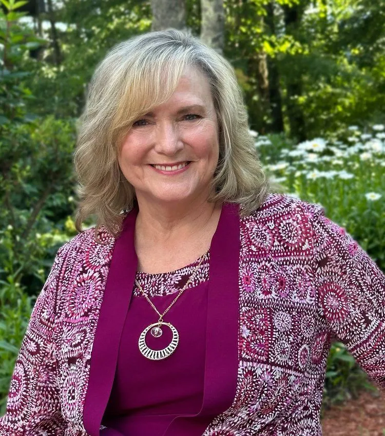 Rev. Debra Brazzel smiling outdoors in a natural, sunlit setting